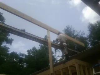 Carpenter setting a ridge beam over a new addition frame — Ice Dam Removal by Roofing Brothers in Tuckahoe