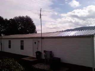 New metal roof on a single wide mobile home with a TV antenna in Tuckahoe