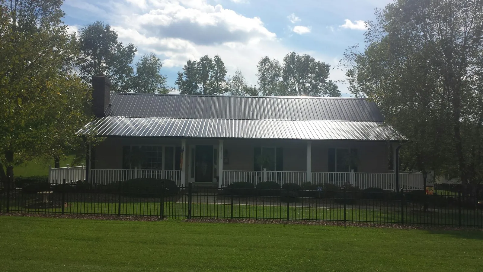 Gray metal roof on a brick ranch with a full width front porch — Gutter Guard Installation work by our crew in Tuckahoe