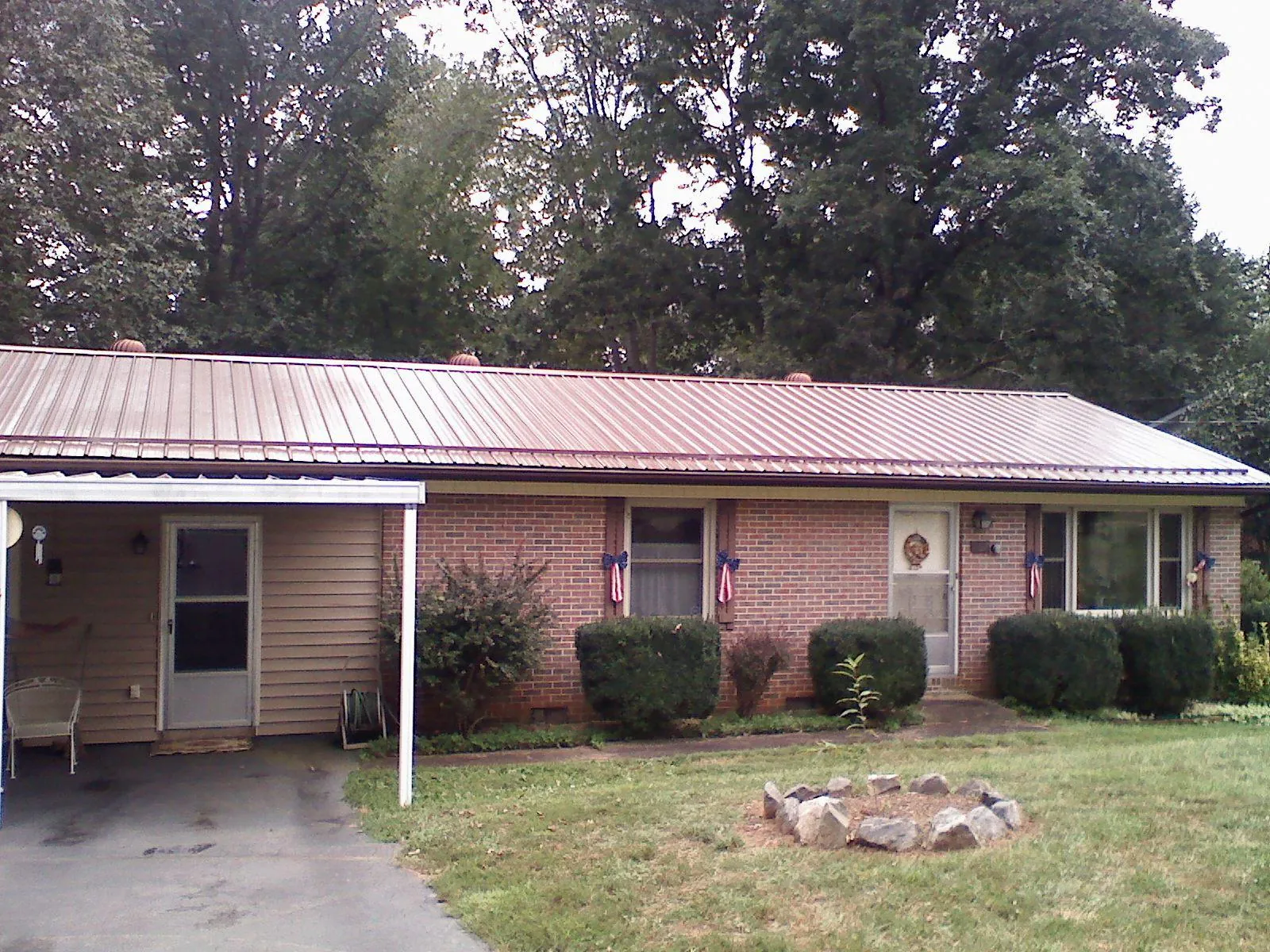 Bronze metal roof and carport on a brick ranch home — Roof Repair work by our crew in Tuckahoe